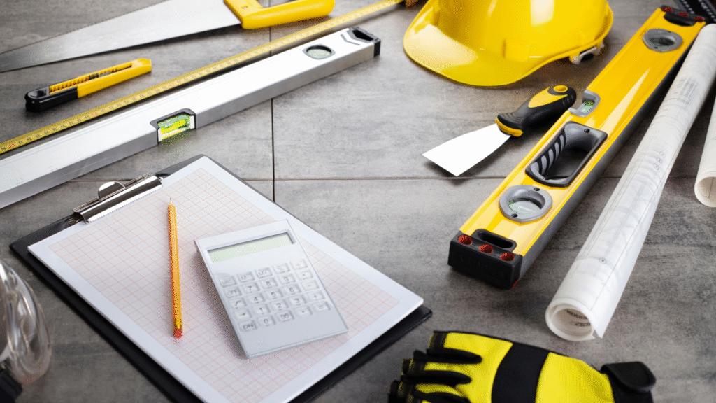 A Pinellas contractor's tools, including a hard hat, blueprints, and a calculator for a professional home remodeling estimate.